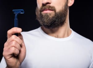 Bearded man is looking at shaver.